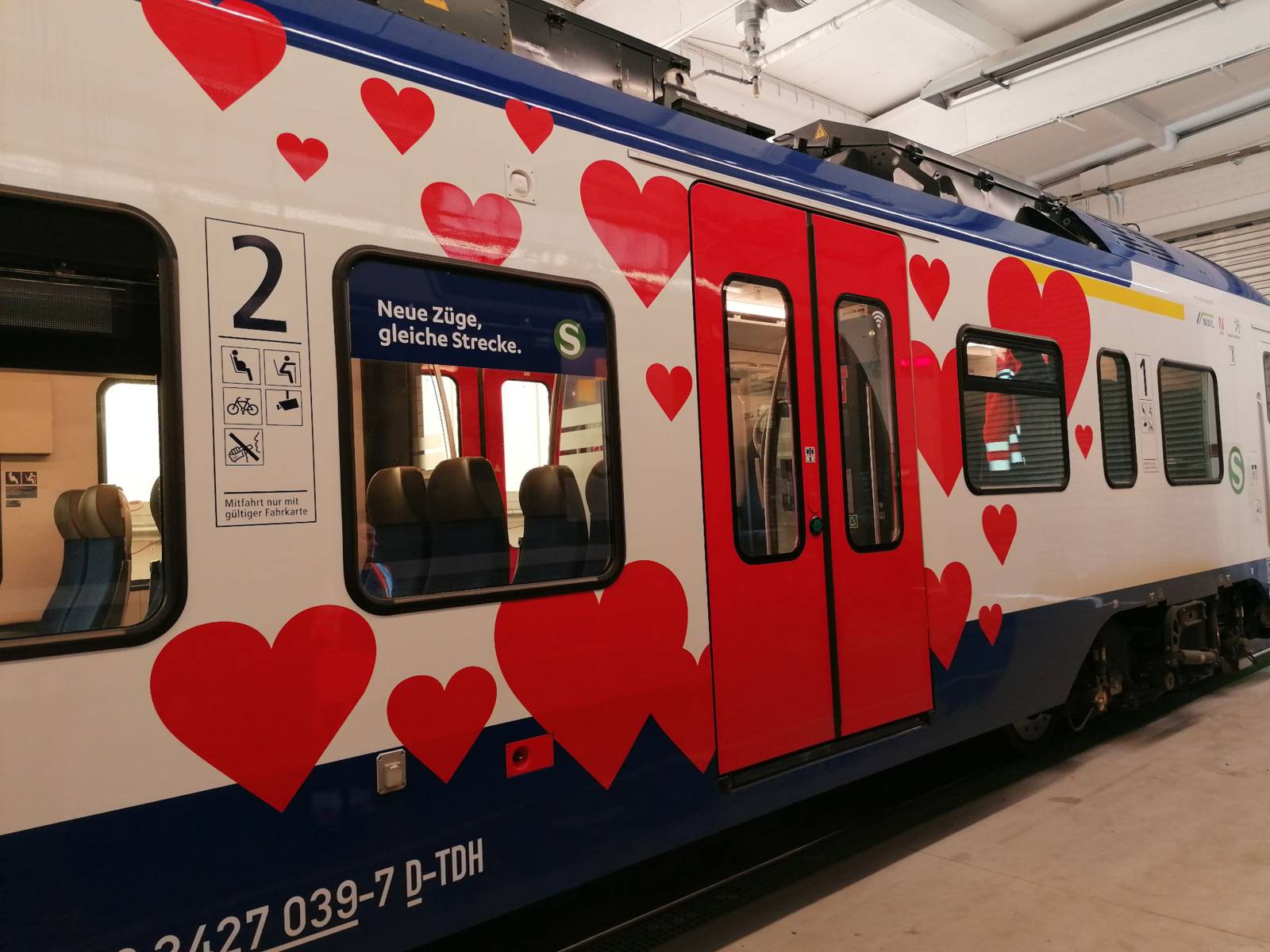 Ein blau-weißer Waggon einer S-Bahn mit roten Herzen rund um die rote Tür